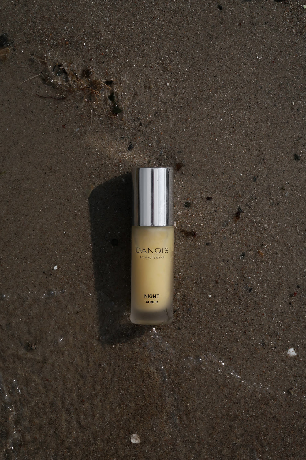Billedet viser DANOIS' Night Creme, som ligger i vandkanten. 