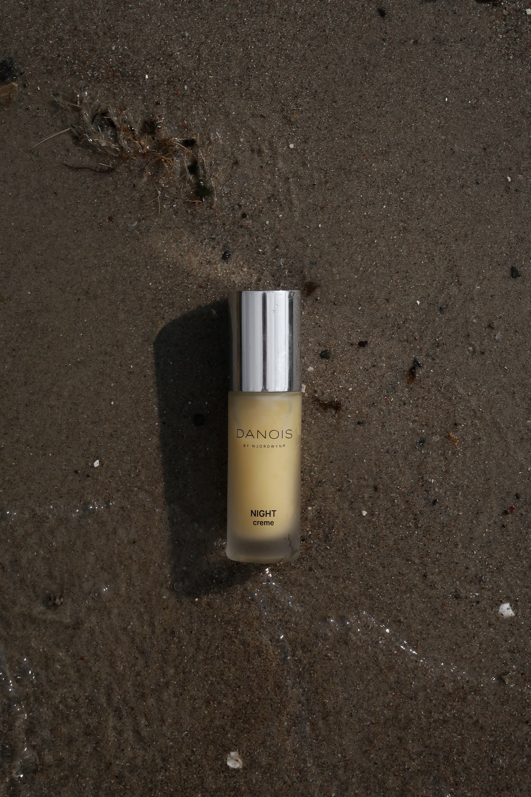 Billedet viser DANOIS' Night Creme, som ligger i vandkanten. 