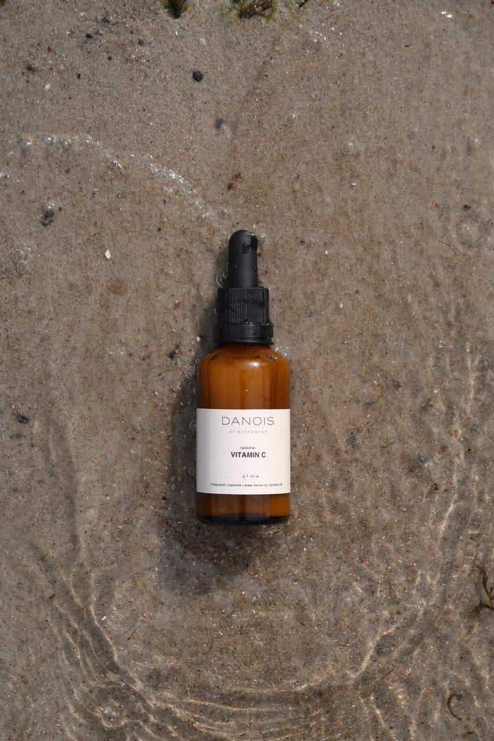 DANOIS' Vitamin C kosttilskud ligger i vandkanten. Vandet laver et fint omrids rundt om produktet